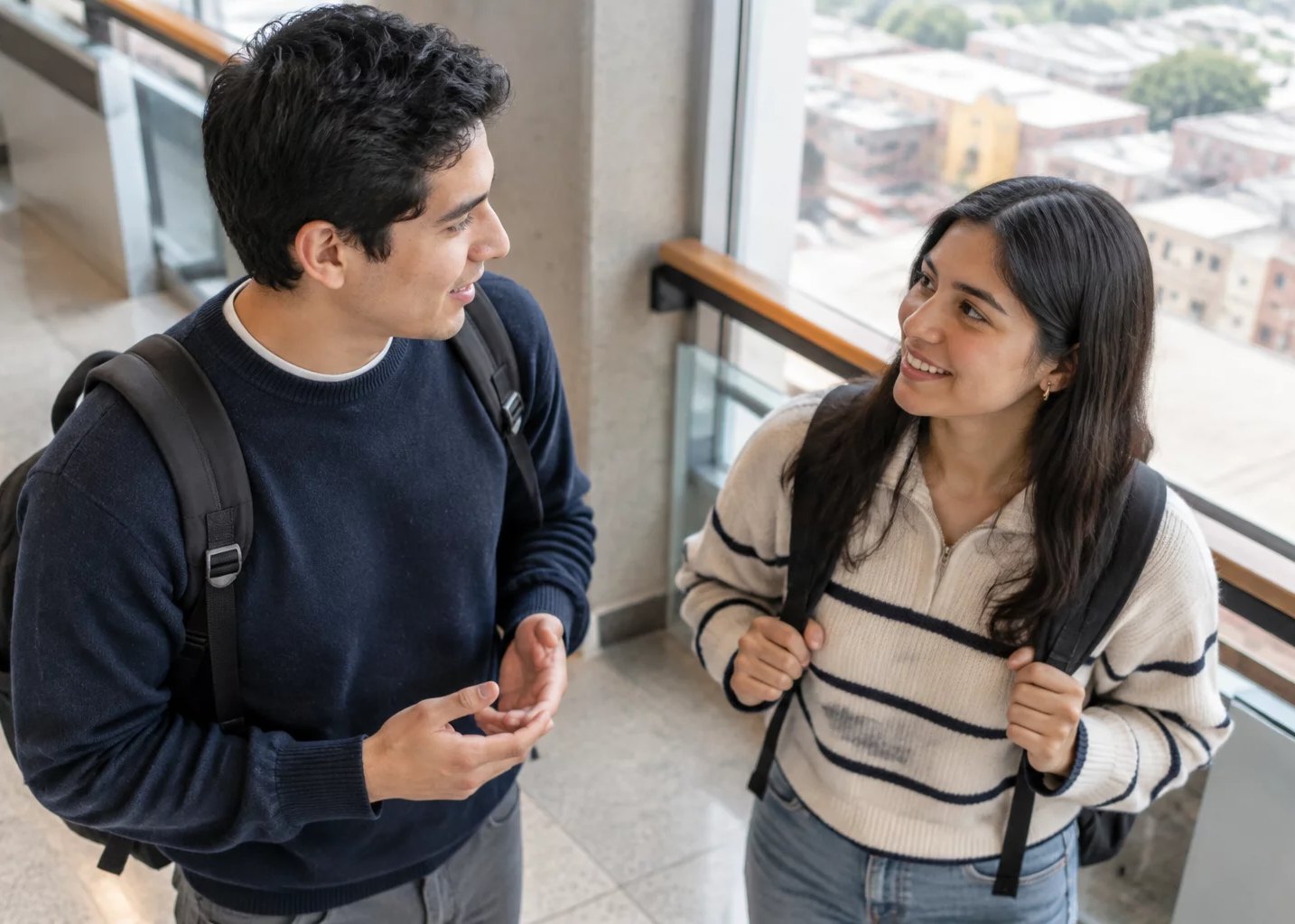 Pasillo de la universidad, con dos estudiantes conversando